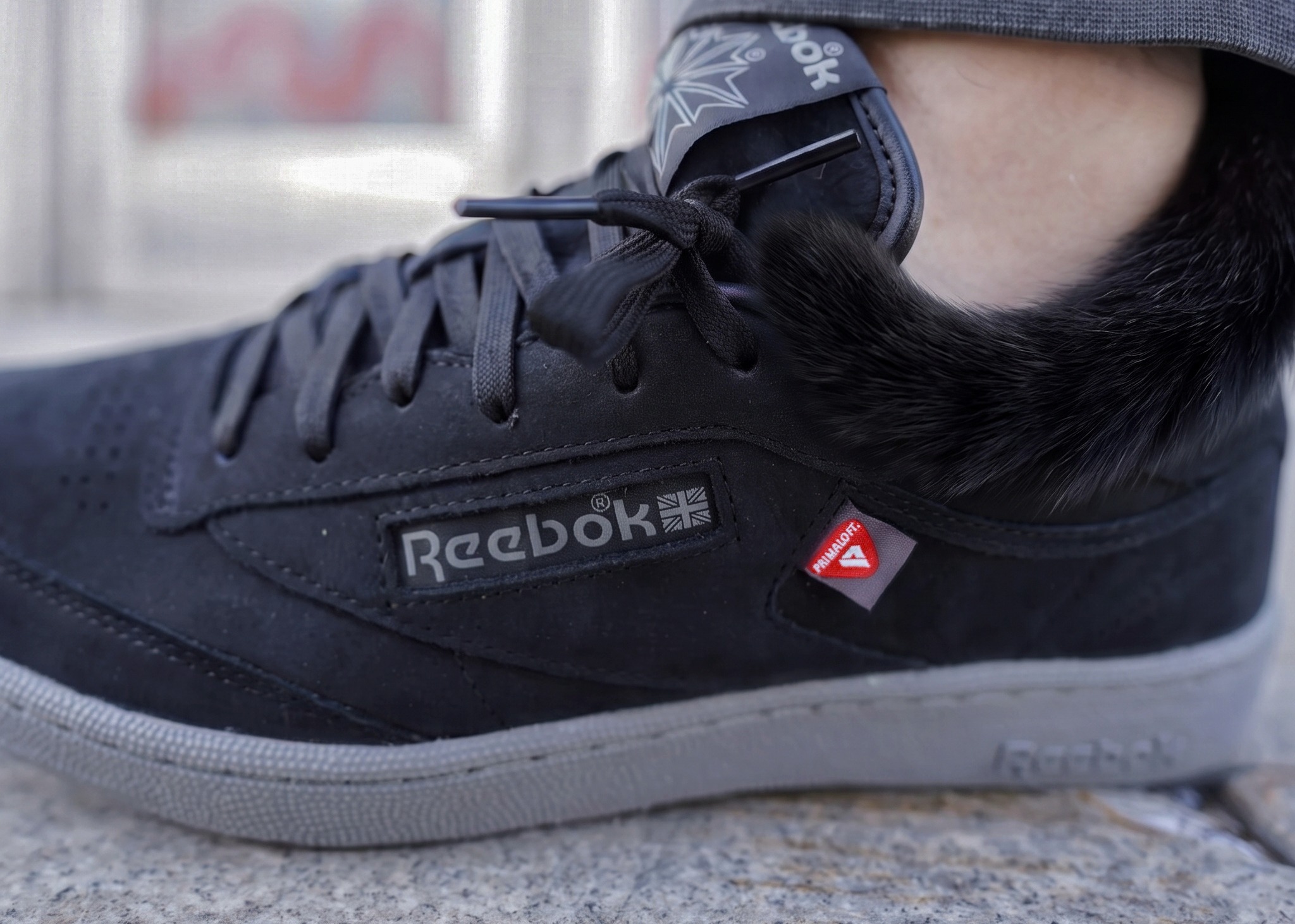 Кроссовки, кеды — называйте как хотите, но в этой расцветке Reebok Club C 85 - просто пушка. Глубокий матовый чёрный превращает спокойный силуэт в настоящего хищника: минималистично, уверенно и очень тактильно.
Верх выполнен из мягкой замши — она приятная, бархатистая, почти как шерсть чёрного кота.